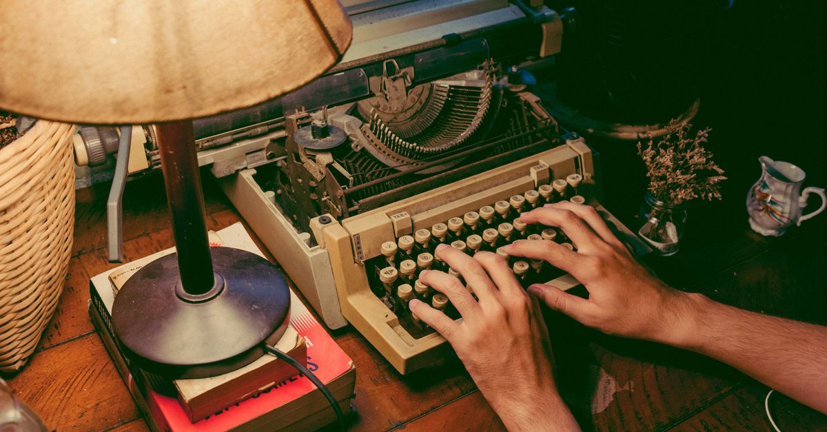 Hands typing on a vintage typewriter, representing a writing-first remote culture